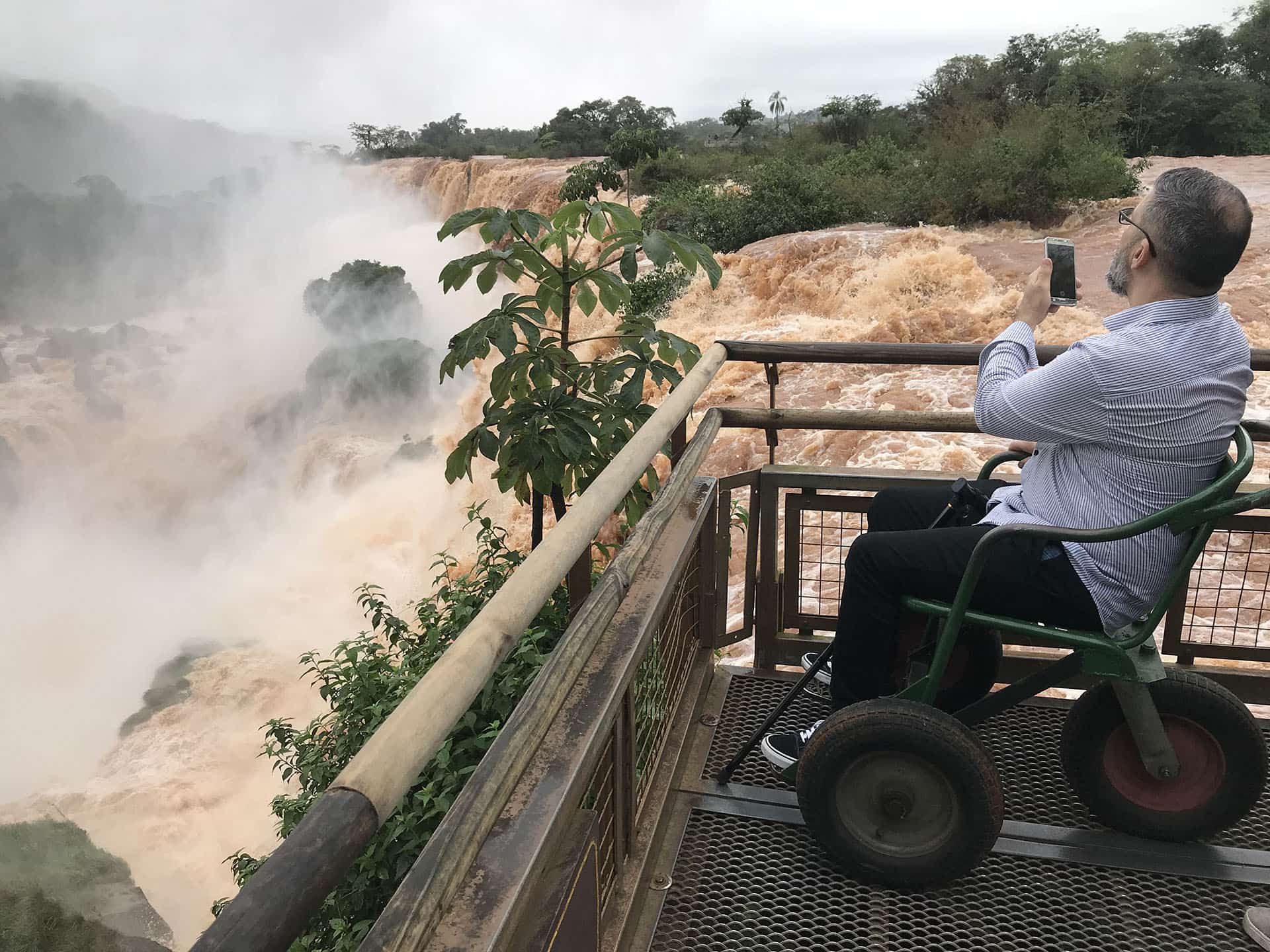Persona con discapacidad motriz en silla de ruedas en plataforma en Cataratas del Iguazú